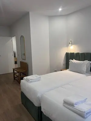 a bedroom with a large bed with towels on it at ORM- Flores Apartment in Porto