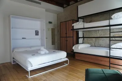 a bedroom with two bunk beds and a chair at The Central House Porto Ribeira in Porto