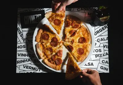 two slices of pizza on a plate on a table at The Central House Porto Ribeira in Porto