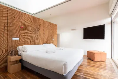 a bedroom with a large bed and a flat screen tv at The Central House Porto Ribeira in Porto