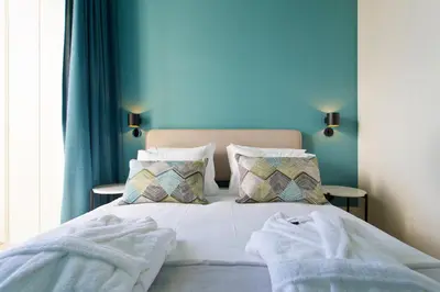 a bed with white sheets and pillows in a bedroom at BOUTIQUE Rentals-Kinga’s Ribeira River great views in Porto