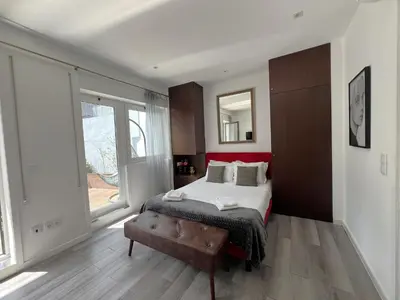 a bedroom with a bed and a large window at Almada Studios & Suites in Porto