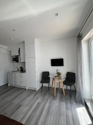 a living room with a table and two chairs at Almada Studios & Suites in Porto