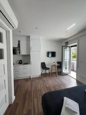 a bedroom with a bed and a kitchen with a table at Almada Studios & Suites in Porto