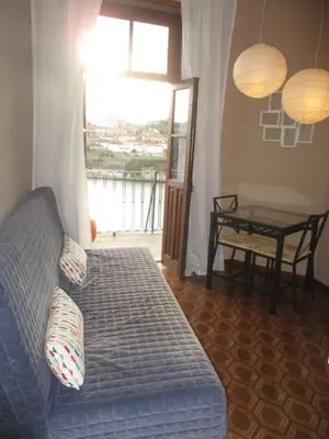 a living room with a couch and a table and a window at Oportobestview-Douro in Porto