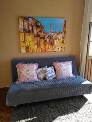 a blue couch in a room with a painting on the wall at Oportobestview-Douro in Porto