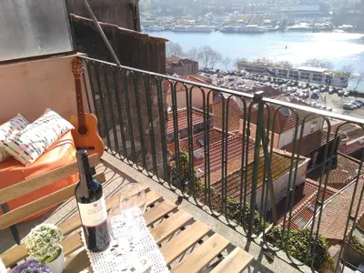 a bottle of wine sitting on a balcony with a guitar at Oportobestview-Douro in Porto