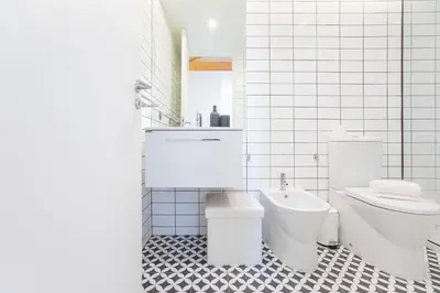 a white bathroom with a toilet and a sink at Modern 2BR Duplex Downtown by Art District by LovelyStay in Porto
