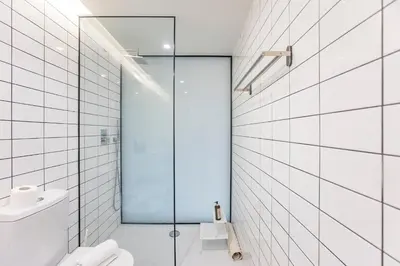 a bathroom with a glass shower and a toilet at Modern 2BR Duplex Downtown by Art District by LovelyStay in Porto