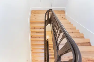 a metal staircase in a home with wooden floors at Modern 2BR Duplex Downtown by Art District by LovelyStay in Porto