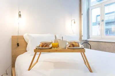 a tray of food on a table on a bed at Trendy Vintage Downtown by LovelyStay in Porto