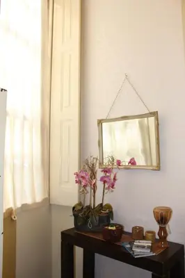a mirror on a wall next to a table with flowers at Oportobestview-Garden in Porto