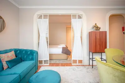 a living room with a blue couch and a bedroom at Liiiving in Porto - Cedofeita Charming Apartment in Porto