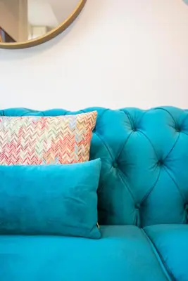 a blue couch with a pillow and a mirror at Liiiving in Porto - Cedofeita Charming Apartment in Porto