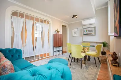 a living room with a blue couch and yellow chairs at Liiiving in Porto - Cedofeita Charming Apartment in Porto