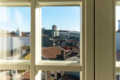 a bedroom with a bed and a lamp on a wall at Portucale Guest House- Self check-in in Porto