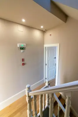 a hallway with windows and a table with a vase at Portucale Guest House- Self check-in in Porto