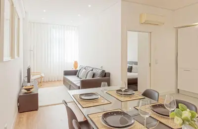 a living room with a table and chairs and a couch at Luxury Prime Batalha Apartments in Porto