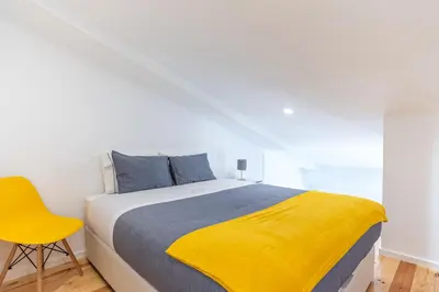 a bedroom with a bed with a yellow blanket on it at Alvaro's Charming Loft by MP in Vila Nova de Gaia