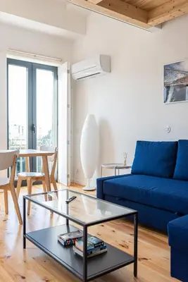 a living room with a blue couch and a table at Alvaro's Charming Loft by MP in Vila Nova de Gaia