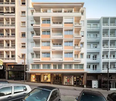 a large building with cars parked in front of it at OportoCityView - Ceuta Aliados in Porto