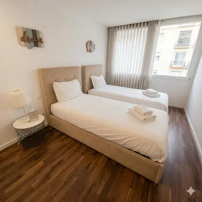 a bedroom with a large bed with white sheets and pillows at OportoCityView - Ceuta Aliados in Porto