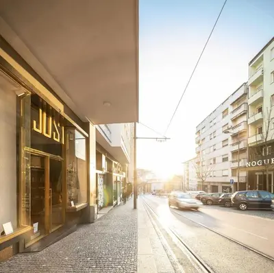 a street with a building and a car on the road at OportoCityView - Ceuta Aliados in Porto