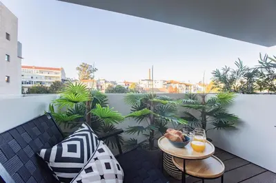 a balcony with a table with drinks and plants at Bombarda Apartments by LovelyStay in Porto