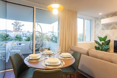 a dining room with a table and a couch at Bombarda Apartments by LovelyStay in Porto