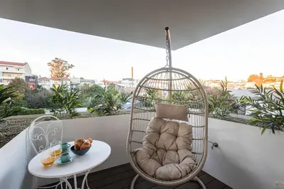 a room with a chair and a table on a balcony at Bombarda Apartments by LovelyStay in Porto