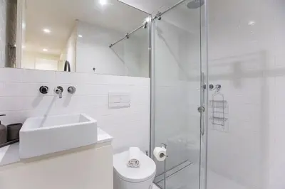 a white bathroom with a sink and a shower at Bombarda Apartments by LovelyStay in Porto