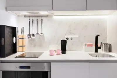 a white kitchen with a sink and a counter at Blue Moon Studio in Porto