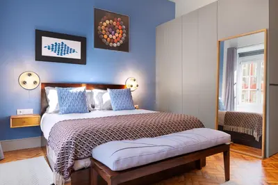 a bedroom with a large bed with blue walls at Blue Moon Studio in Porto
