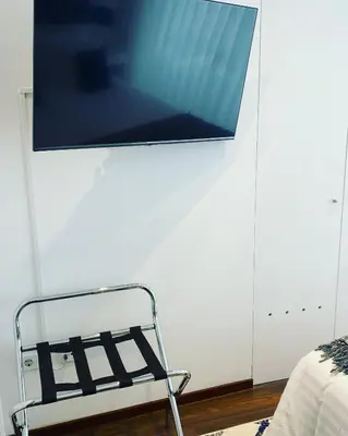 a tv hanging on a wall next to a bed at Lapa City Loft in Porto