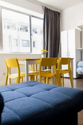 a bedroom with a table and chairs and a bed at Travel & Live Bolhão apartments in Porto
