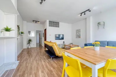 a dining room with a wooden table and yellow chairs at Travel & Live Bolhão apartments in Porto