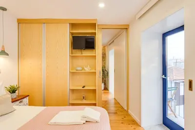 a bedroom with a bed and a tv on a shelf at Riverside 2 Bedroom Apartment by DA'HOME in Porto