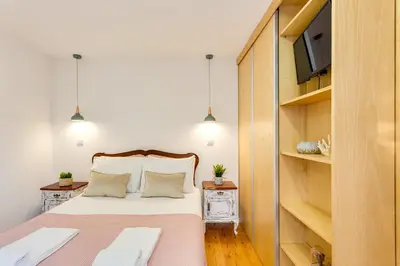 a small bedroom with a bed and a tv at Riverside 2 Bedroom Apartment by DA'HOME in Porto