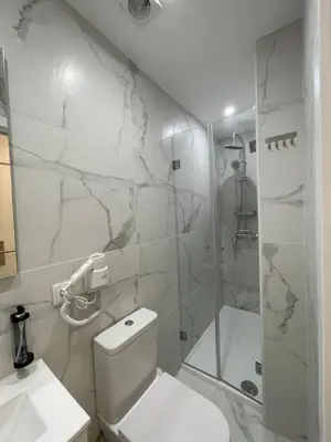 a bedroom with a bed and a bathroom with a shower at MyStay Porto São Bento in Porto