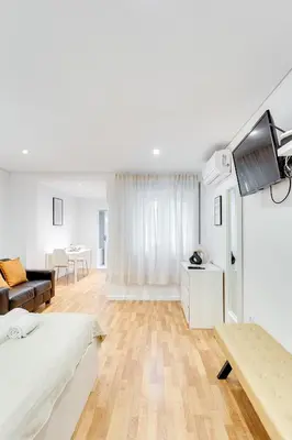 a white room with a bed and a tv in it at Bonjardim Downtown Apartments by DA'HOME in Porto