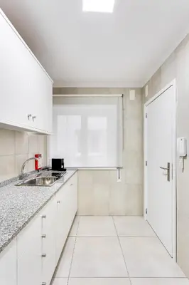 a kitchen with white cabinets and a sink at Bonjardim Downtown Apartments by DA'HOME in Porto