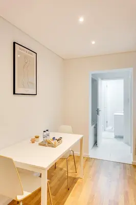 a white dining room with a white table and chairs at Bonjardim Downtown Apartments by DA'HOME in Porto