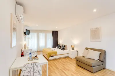 a living room with a bed and a couch at Bonjardim Downtown Apartments by DA'HOME in Porto