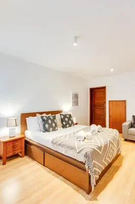 a bedroom with a large bed and a chair at Bonjardim Downtown Apartments by DA'HOME in Porto