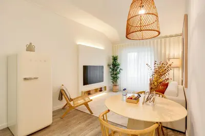 a kitchen and living room with a table and a refrigerator at Virtudes Premium Apartment by DA'HOME in Porto