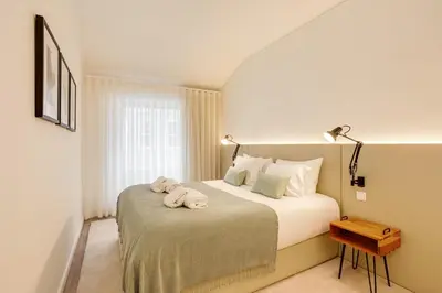 a bedroom with a bed with two towels on it at Virtudes Premium Apartment by DA'HOME in Porto