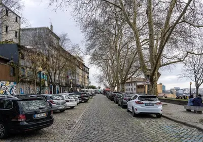 a row of cars parked on a cobblestone street at Virtudes Premium Apartment by DA'HOME in Porto