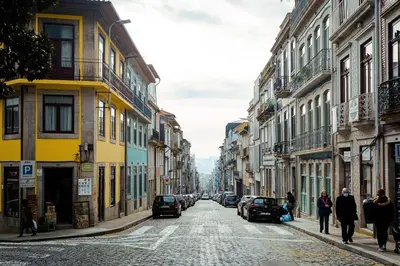 a city street with buildings and people walking down the street at Almada Downtown Apartment by DA'HOME in Porto