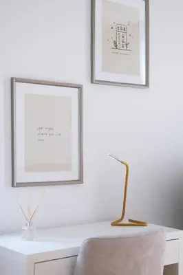 a white desk with two framed pictures and a chair at Almada Downtown Apartment by DA'HOME in Porto