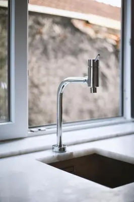 a kitchen sink with a faucet next to a window at Almada Downtown Apartment by DA'HOME in Porto